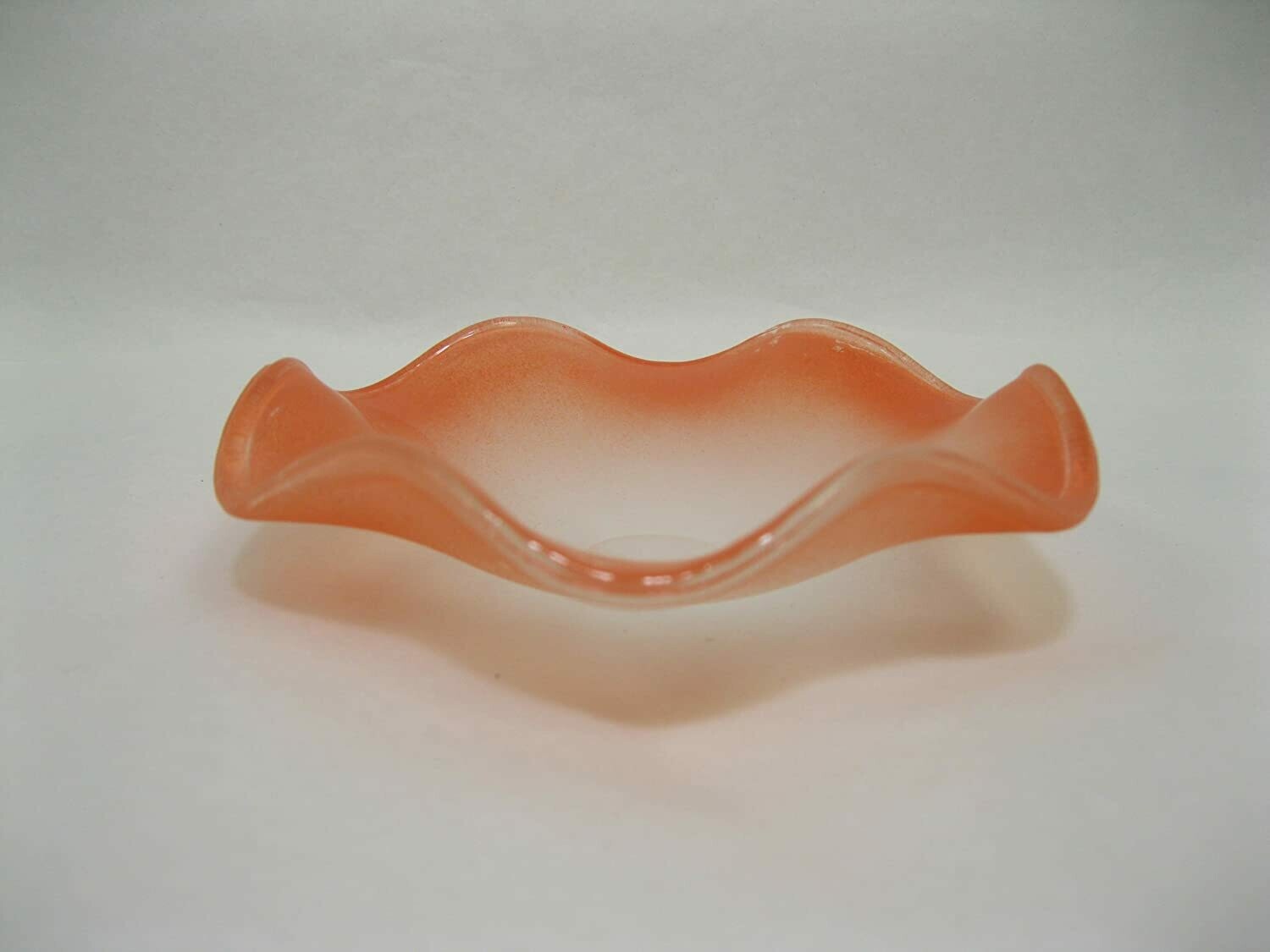 Picture of a frosted orange wavy glass replacement bowl for an aroma lamp. 