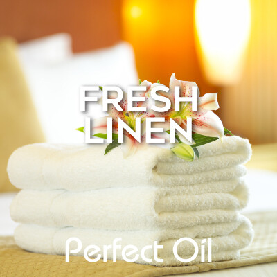 Picture showing three folded white towels with two plumeria flowers on top against a sunlit background with the words fresh linen and Perfect Oil in white on top of the image itself. 