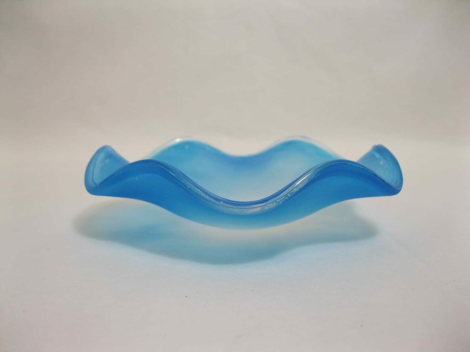 Picture of a frosted blue wavy glass replacement bowl for an aroma night light. 
