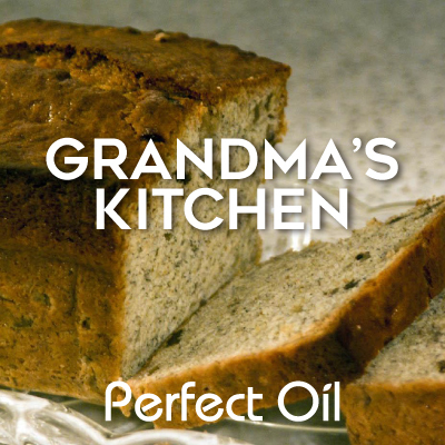 Picture showing a banana bread with two slices cut and laying on each other on a white tablecloth with the words grandma's kitchen and Perfect Oil in white on top of the image itself. 