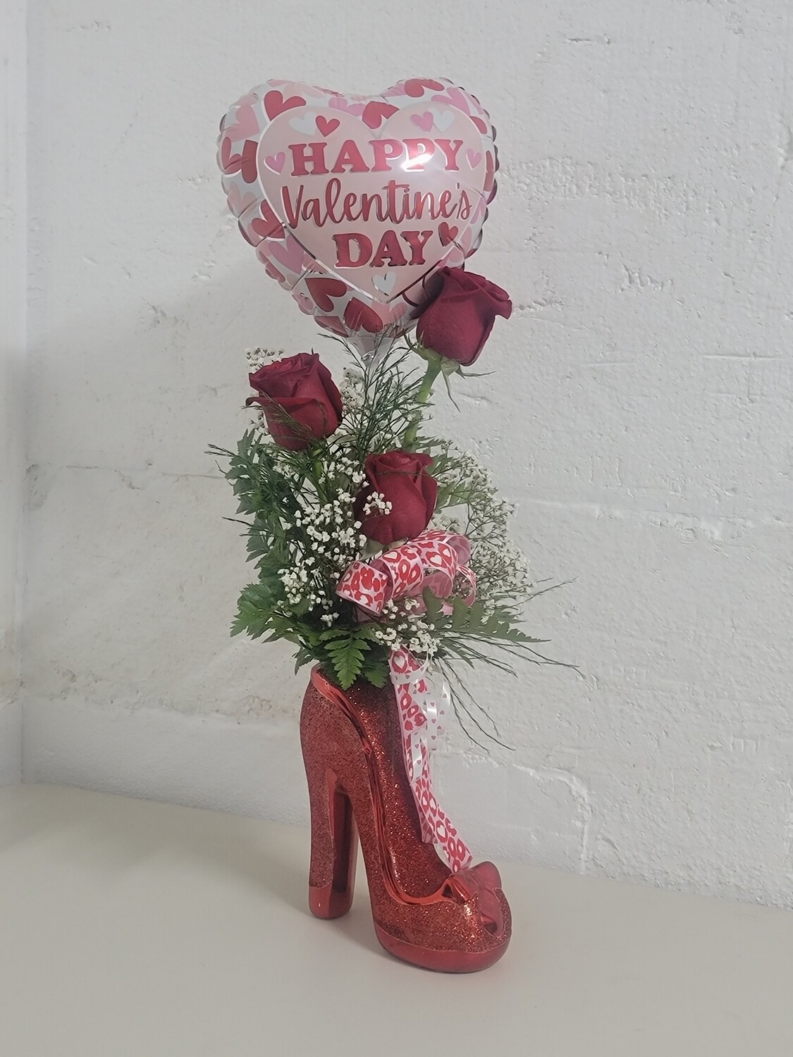 3 roses and a balloon in a shoe vase