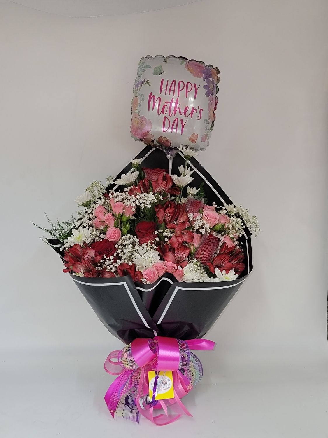 Cut flowers in a black wrap with a balloon