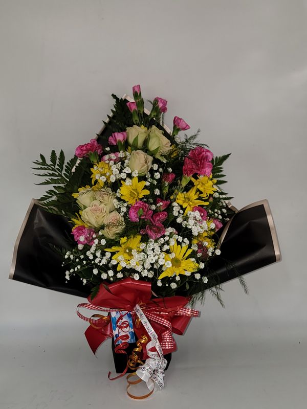 Cut flowers in a peach wrap and a ballloon