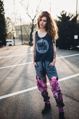 Dame trägt graue Fleece-Jogginghose mit auffälligem rosa Pferde-Design, ideal für Outdoor, langlebig und pflegeleicht.