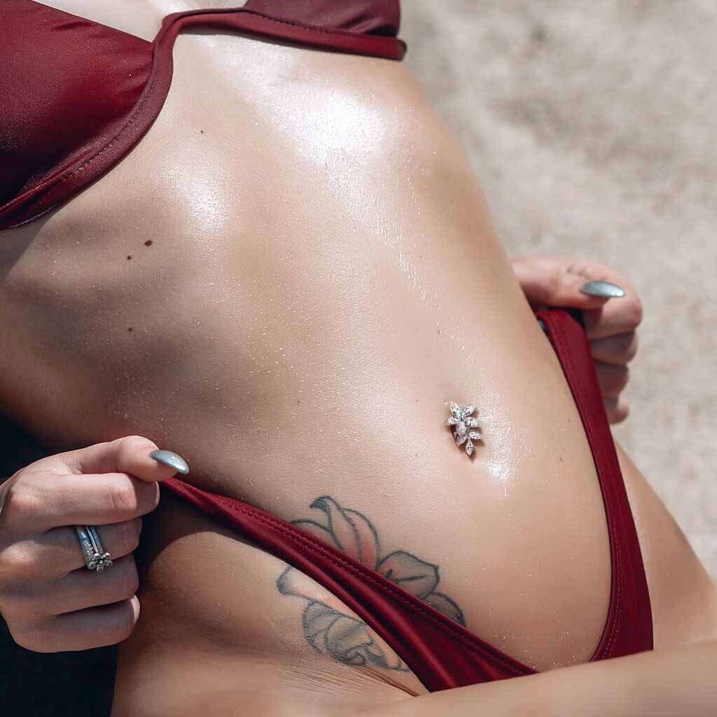 Piercing au nombril inversé bouquet de fleurs blanches