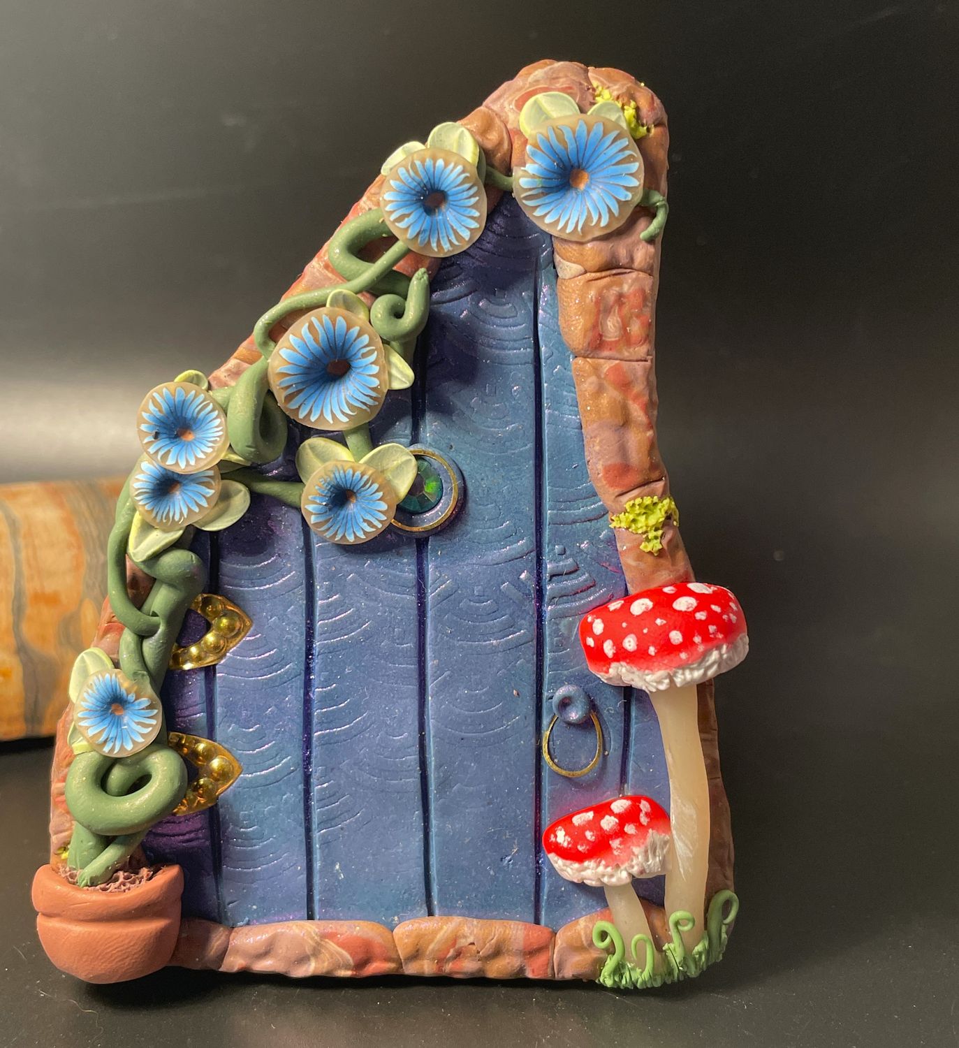 Blue Fairy Door with climber and red mushrooms