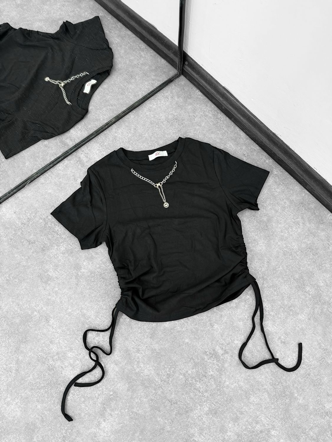 Remera con cadena y cordones a los costados
