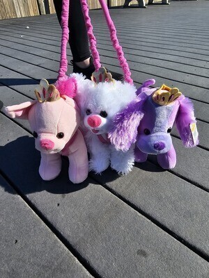 Pink, white and purple princess puppy plushies on leashes shown on Jenkinson&#39;s Boardwalk 