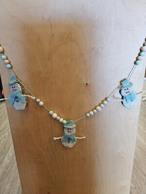 A string of snowman garland (three of five snowmen shown) with a beachy flair. 