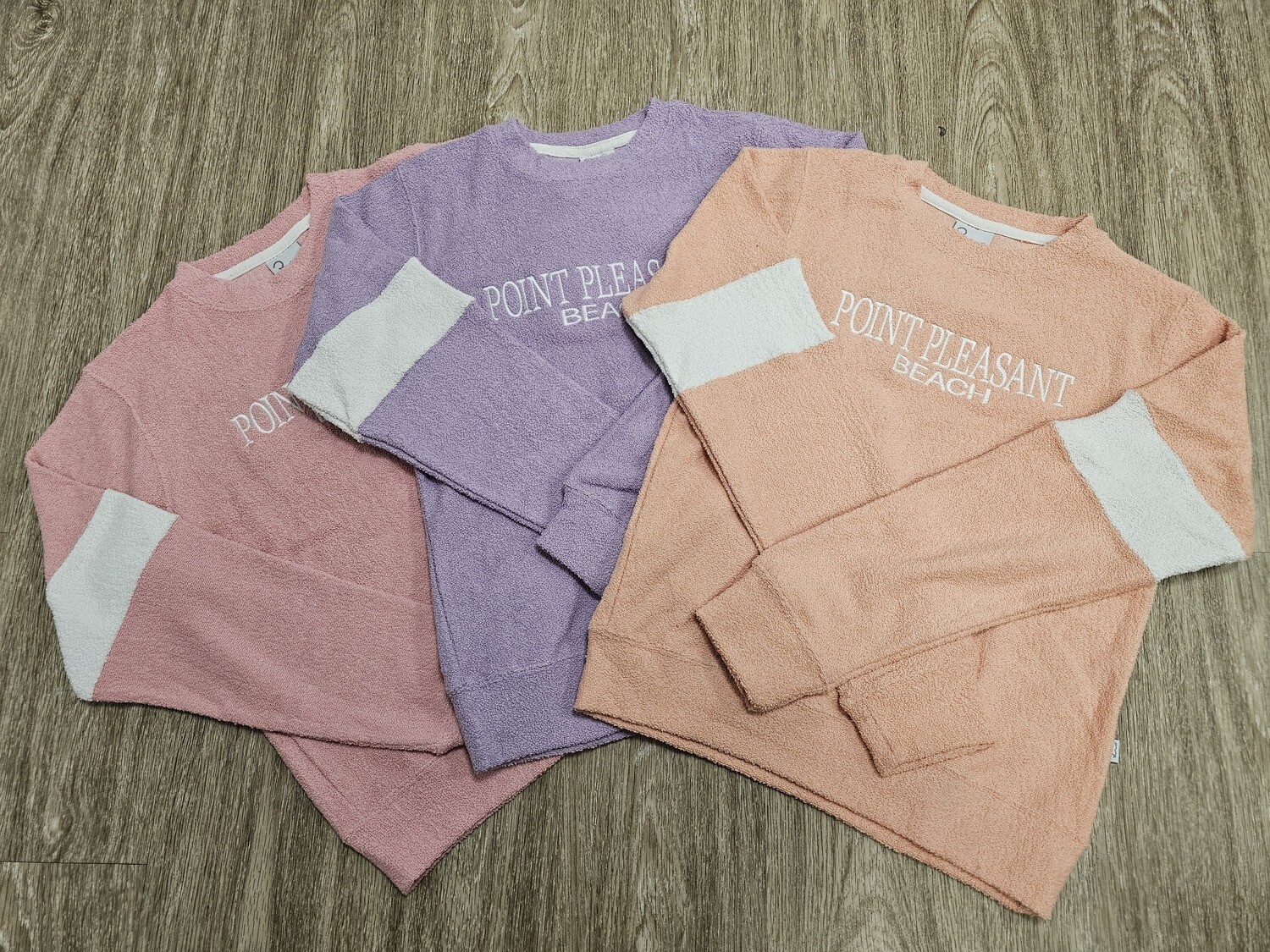 Terry crew sweatshirts that say Point Pleasant Beach shown in Coral, Lilac, and Pink