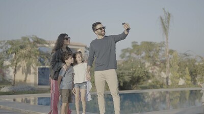 عائلة مكونة من اربعة افراد تلتقط صورة سيلفى فى الحديقة 