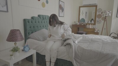 a woman sitting in bed waking up