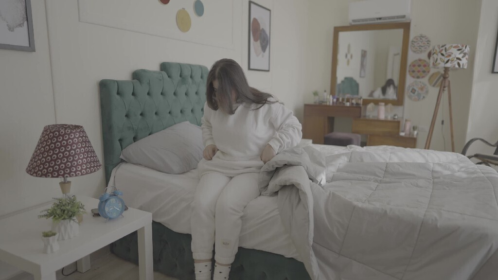 a woman sitting in bed waking up