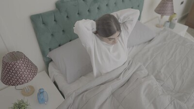 a woman sitting in bed waking up