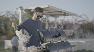 man preparing food on a barbecue grill