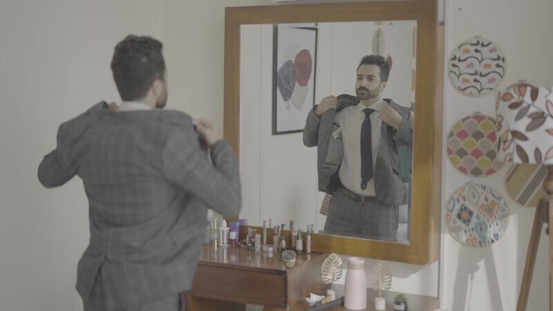a man standing in front of a mirror wearing a jacket