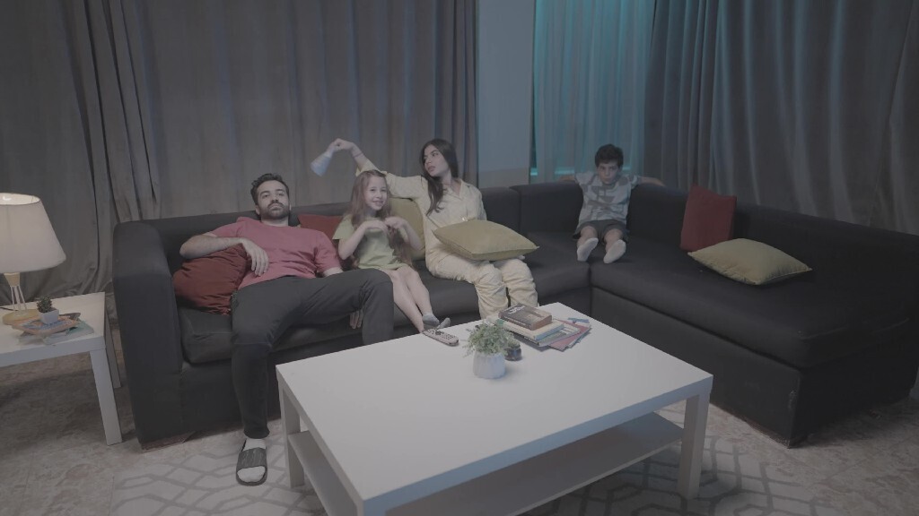 a family of four watching television