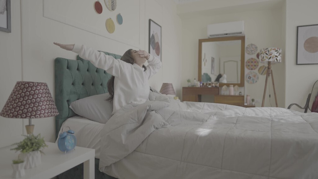 a woman sitting in bed waking up