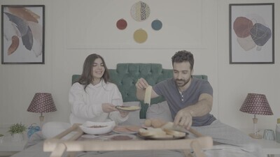 a man and a woman having breakfast on the bed
