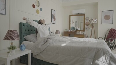 a woman sitting in bed waking up