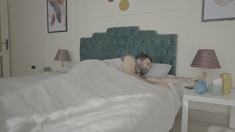 a man sitting in bed waking up