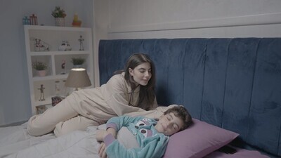 امراة تجلس بجانب ابنها وهو نائم 