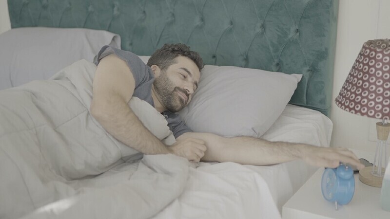 a man sitting in bed waking up