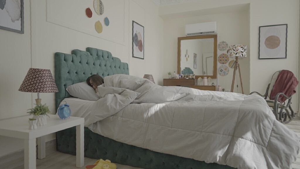 a woman sitting in bed waking up