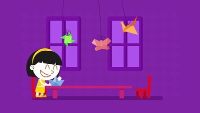 a little girl playing with paper on a purple background