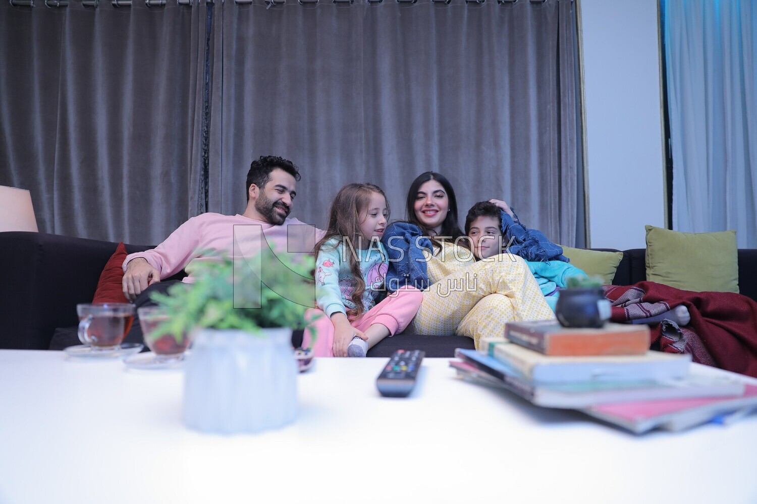 a family of four watching television