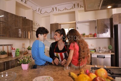 a woman with her kids in the kitchen