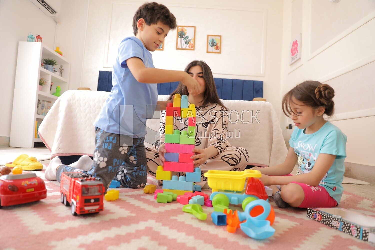 a woman sitting with her children playing
