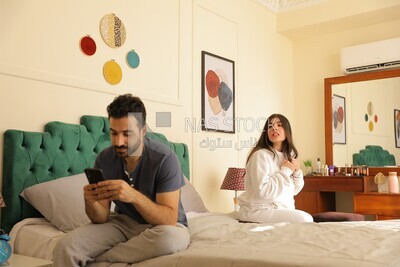 a man texting on the phone while her wife is beside him