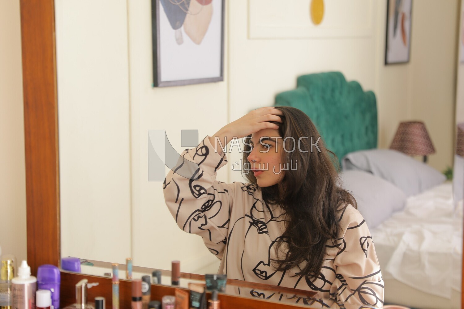a woman sitting in front of the mirror brushing her hair