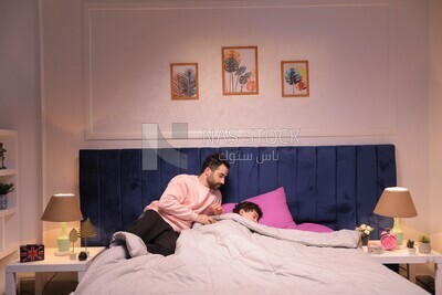 a father sitting on the bed during his boy&#39;s sleep