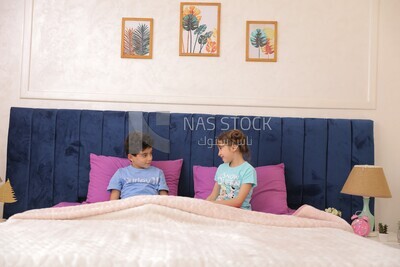 a brother and his sister lying in bed