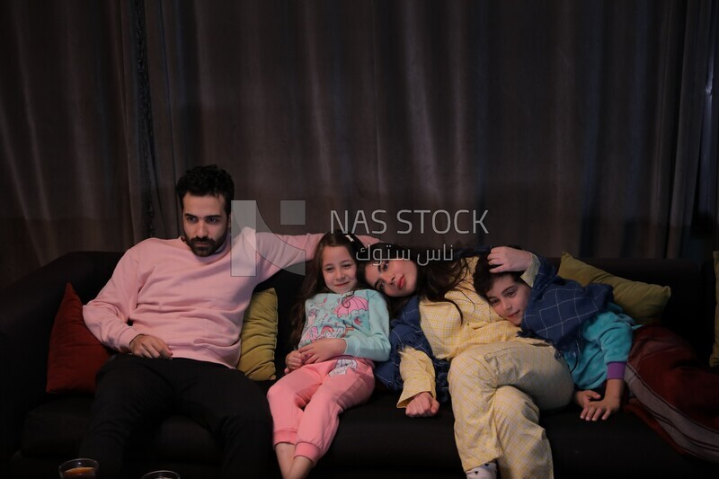 a family of four watching television