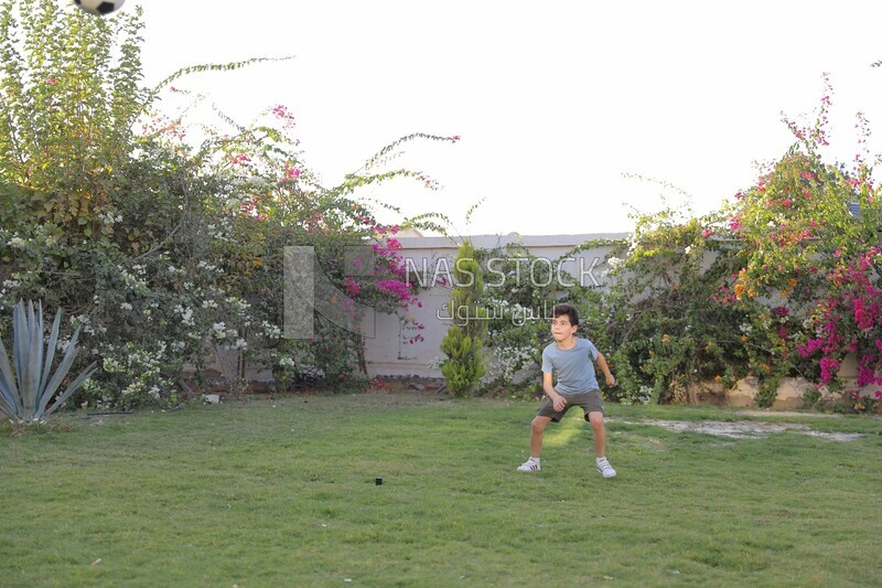 a boy playing football in the garden