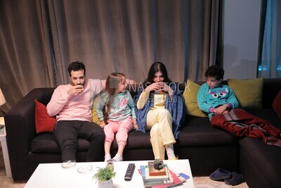 a family of four watching television