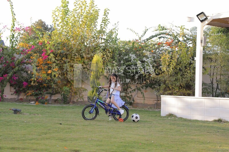 a girl riding a bike in the garden