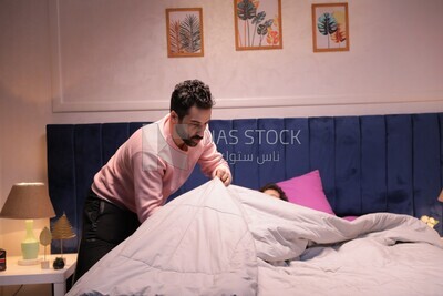 a father sitting on the bed during his boy&#39;s sleep