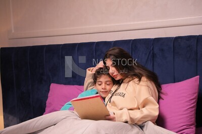 a woman reading a story to her son in bed