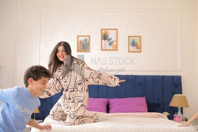 امراة تجلس مع اطفالها يلعبون 