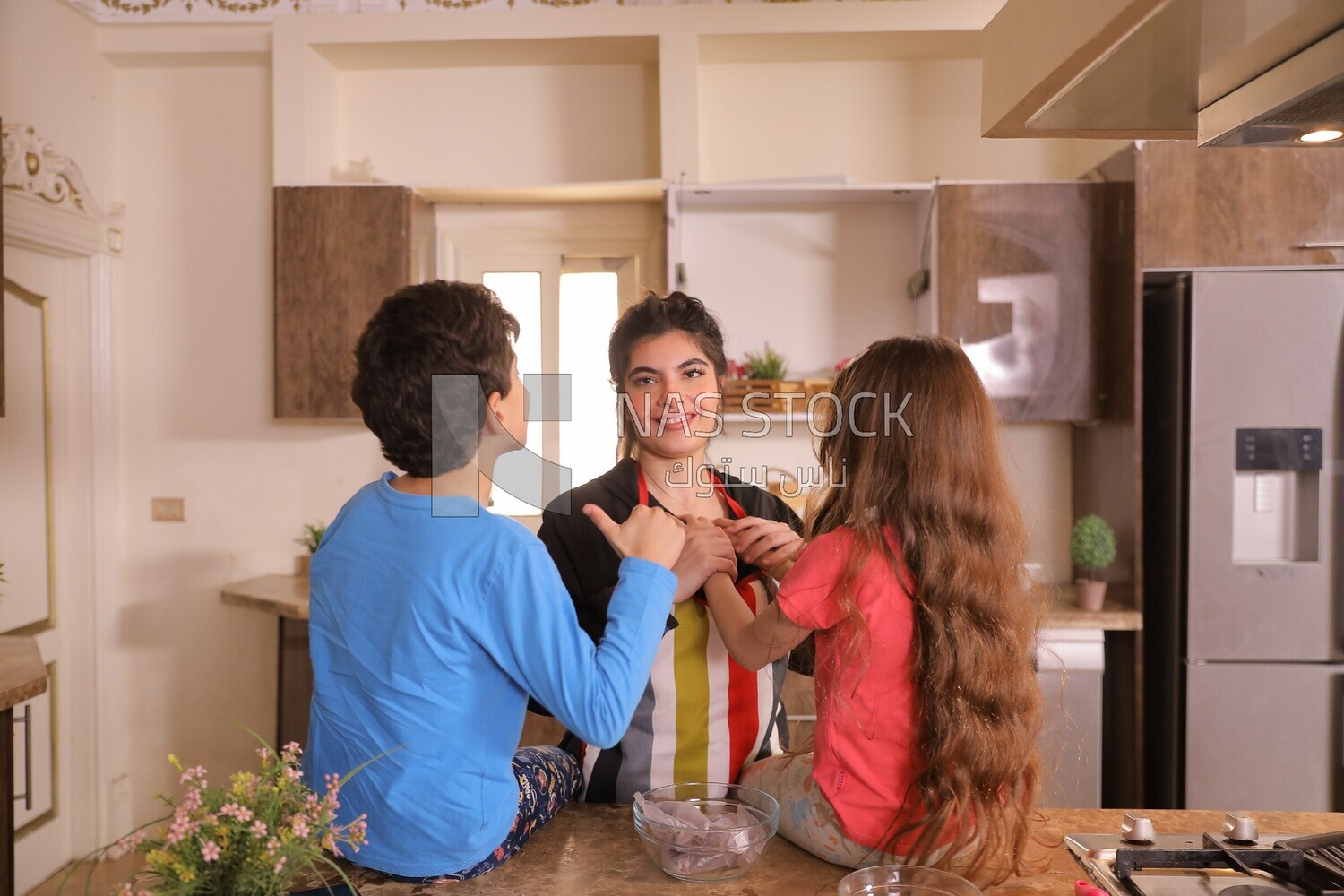 a woman with her kids in the kitchen
