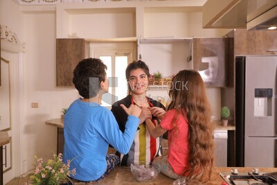 a woman with her kids in the kitchen