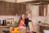 a mother with her girl in the kitchen taking selfie