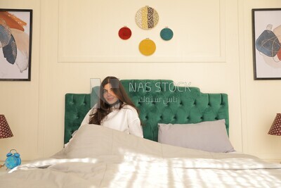 a woman sitting in bed waking up