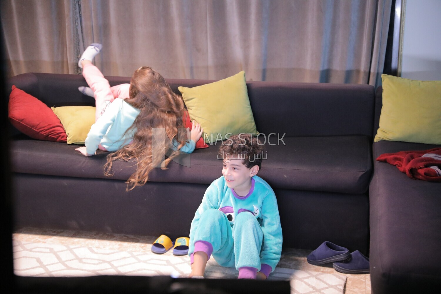a brother and a sister playing in the living room