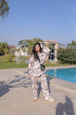 a woman standing in the garden beside a swimming pool