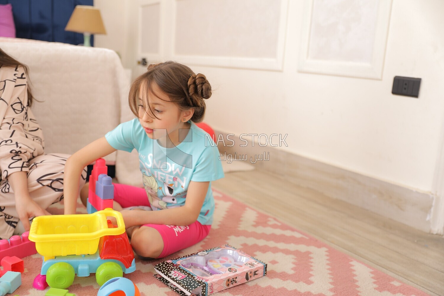 a girl sitting on the floor and playing